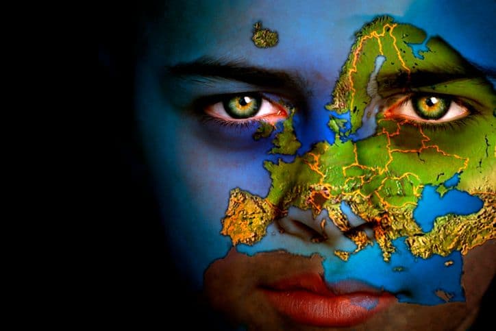 Portrait d'un garçon sur le visage duquel figure la carte du monde