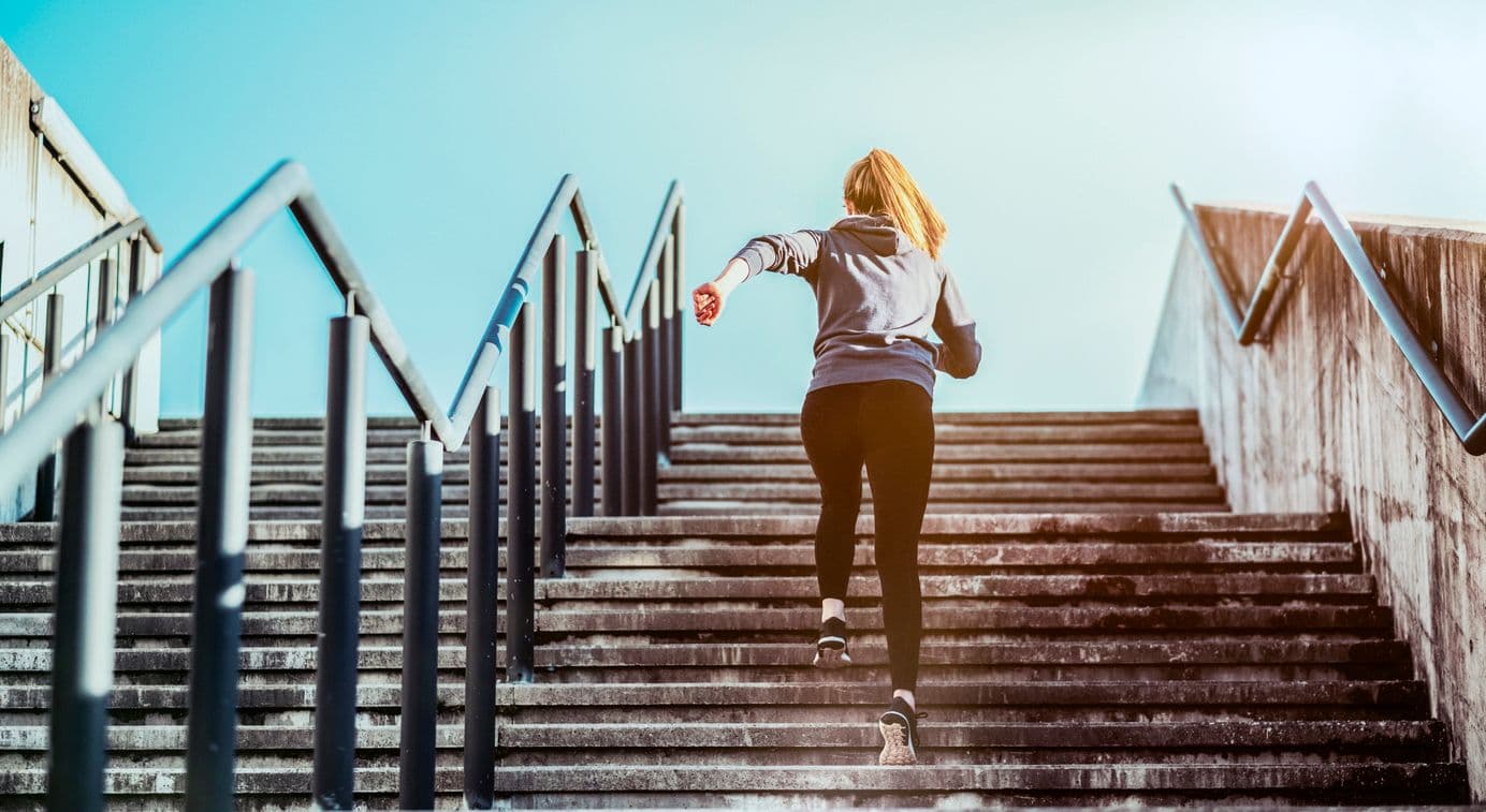 Jeune femme montant un escalier en courant