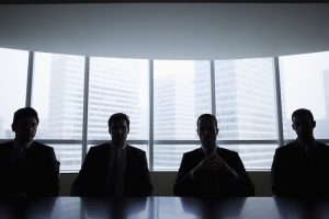 Silhouettes d'hommes d'affaires assis dans une salle de réunion