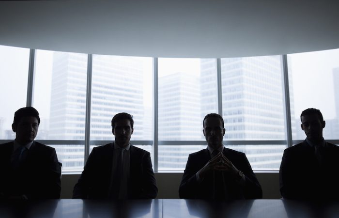 Silhouettes d'hommes d'affaires assis dans une salle de réunion