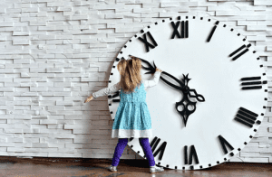 Petite fille devant une horloge