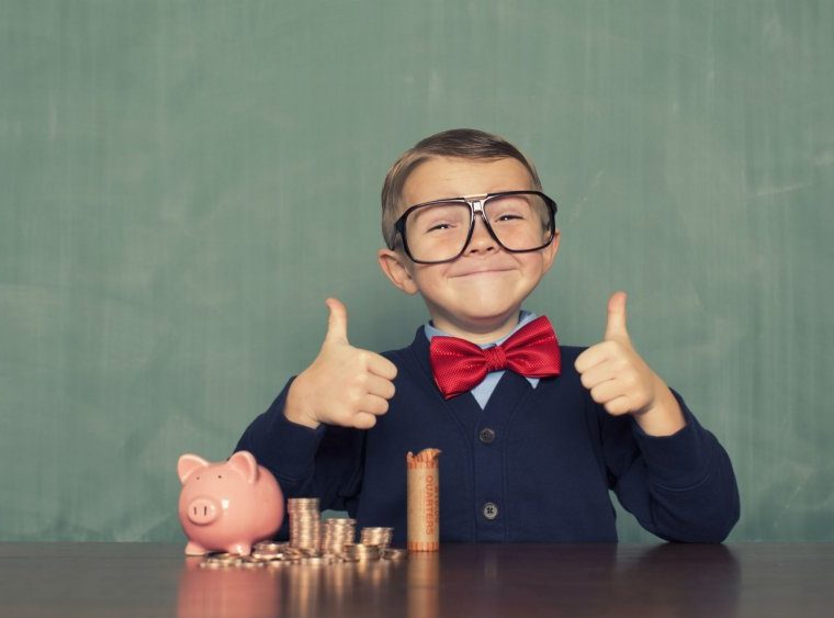 Petit garçon pouces en l'air devant un tas de pièces