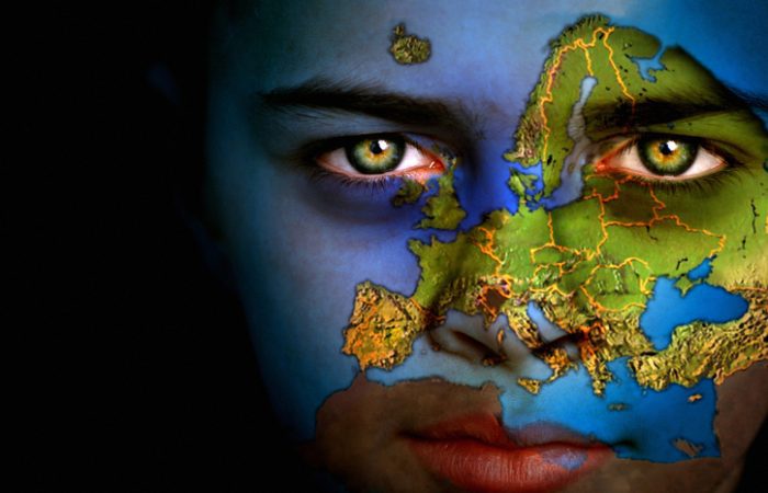 Portrait d'un garçon sur le visage duquel figure la carte du monde