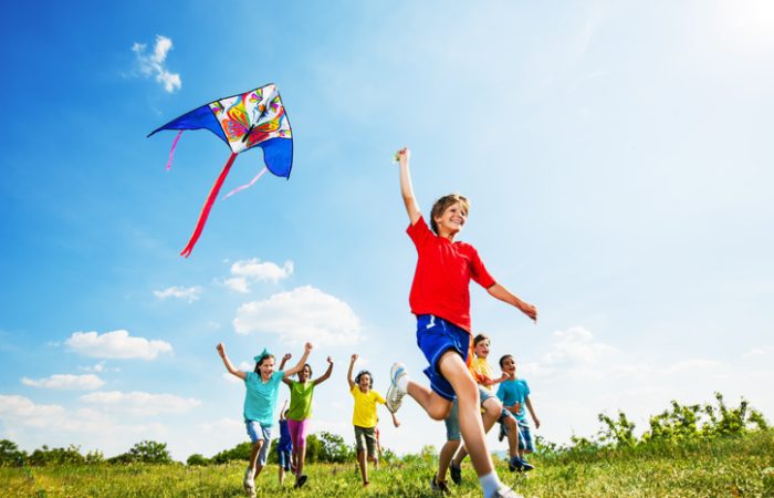 Enfants joyeux jouant avec un cerf-volant