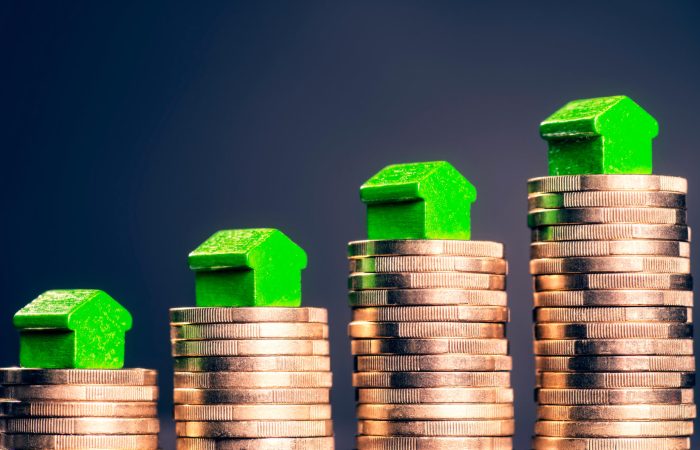 Petites maisons vertes sur piles de pièces