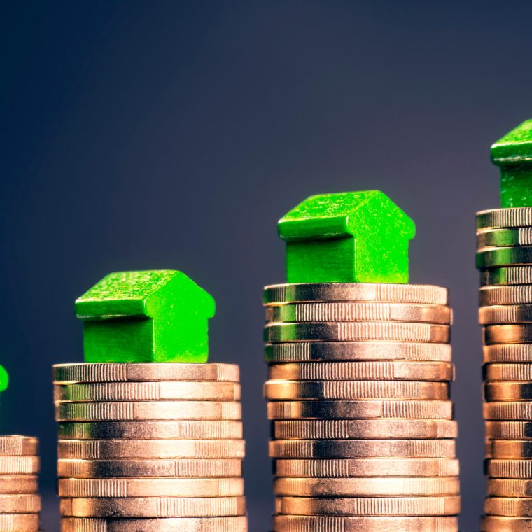 Petites maisons vertes sur piles de pièces