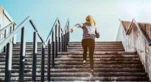 Jeune femme montant un escalier en courant