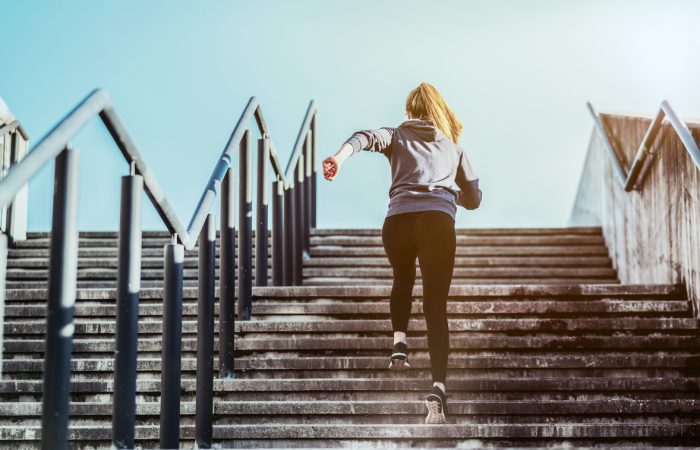 Jeune femme montant un escalier en courant