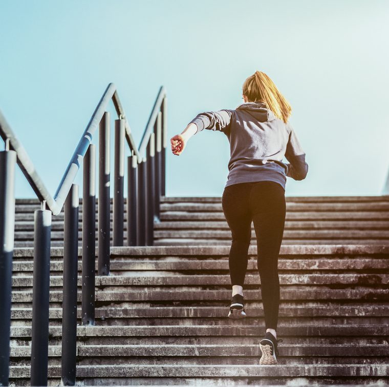 Jeune femme montant un escalier en courant