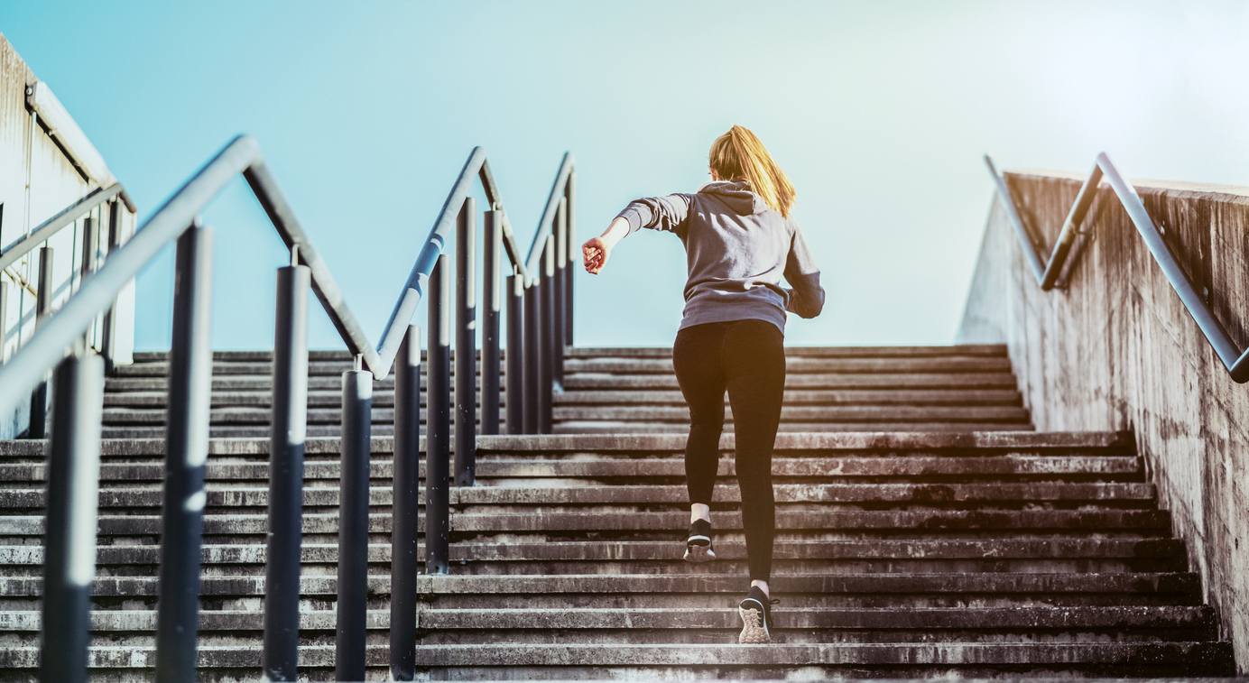 Jeune femme montant un escalier en courant
