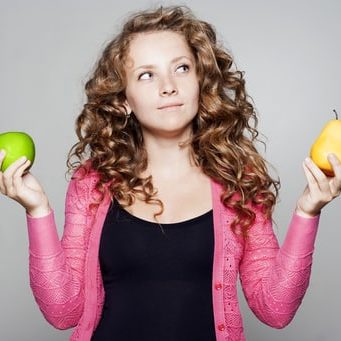Jeune femme tenant pomme et poire dans chaque main
