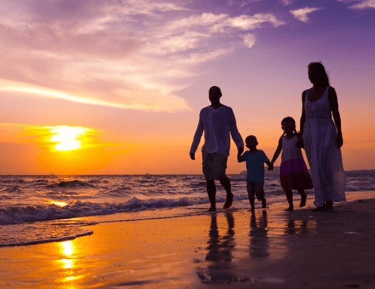 Famille se promenant sur la plage - coucher de soleil